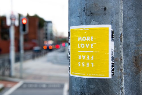 street sign reading 'more love, less fear'