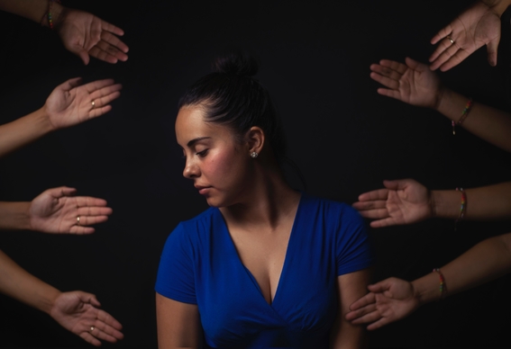 woman in blue top rejecting hands reaching out to her