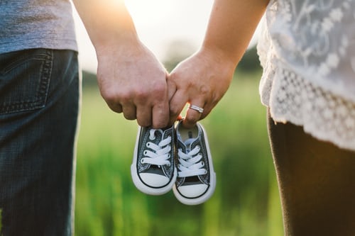 couple holding new baby shoes