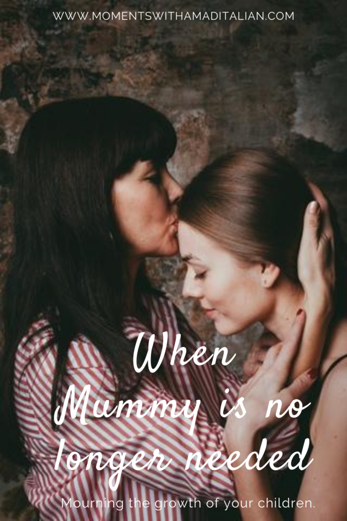 mother kissing adult daughter on the forehead