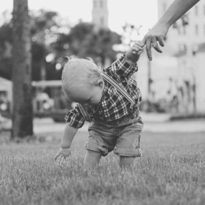 monochrome image of child noticing something in the grass