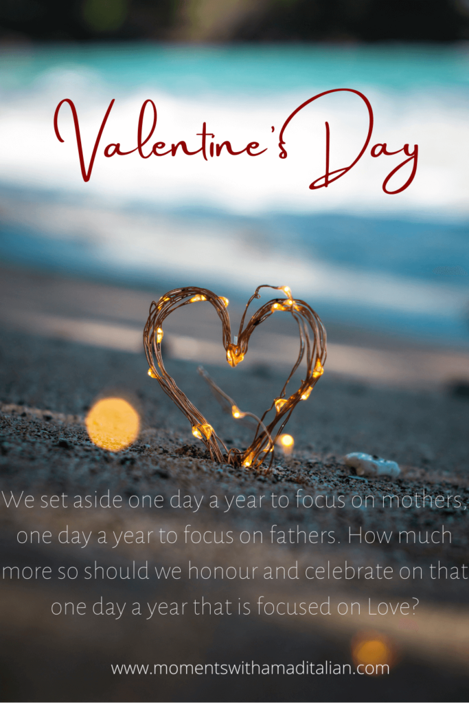 wire lights shaped into a heart, inserted in the sand with beach behind it.