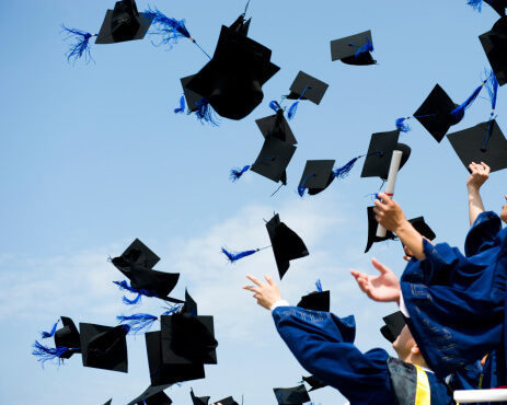 students throwing their graduation hats into the air
